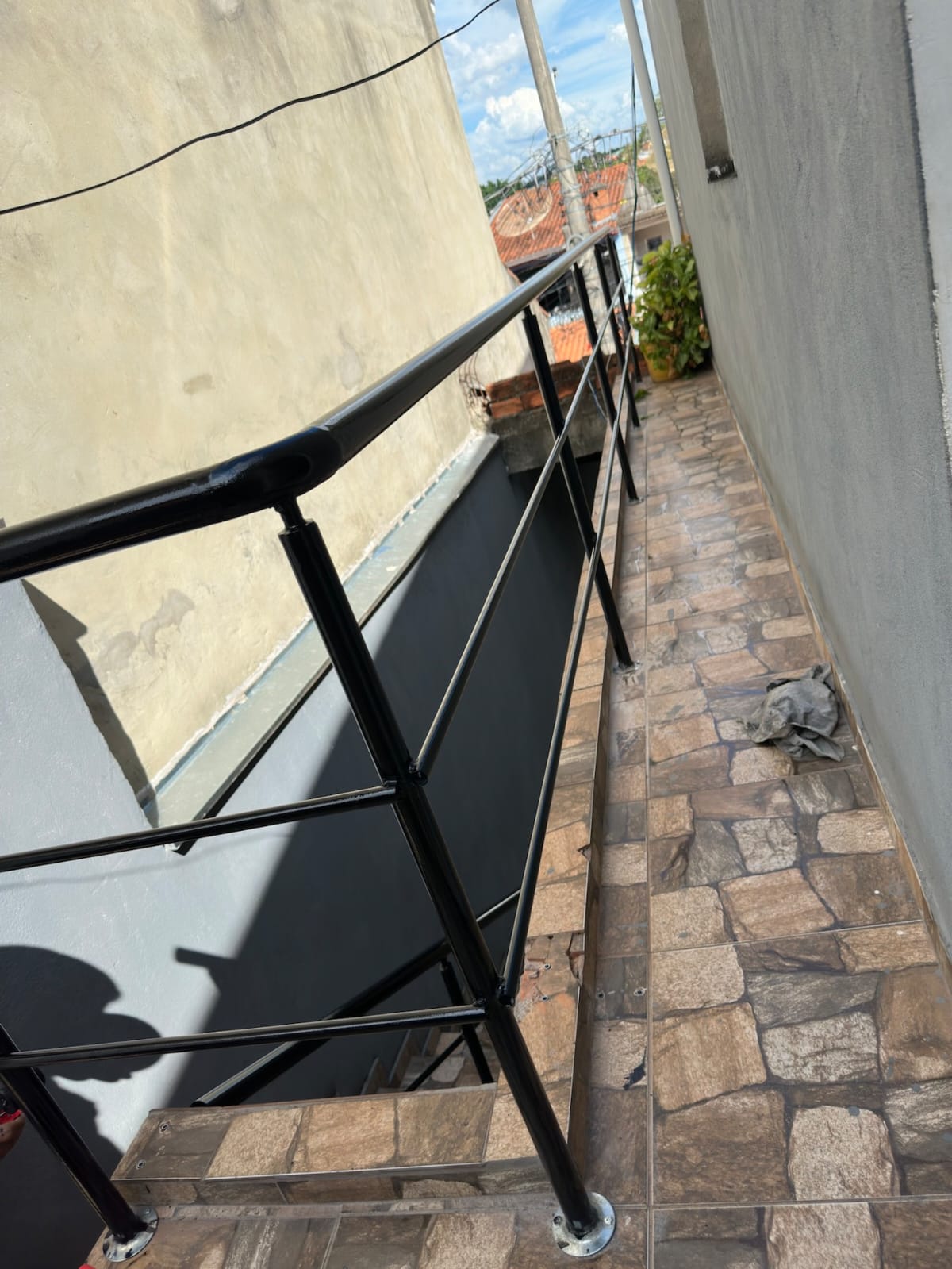 Guarda-corpo e corrimão tubular preto em corredor externo