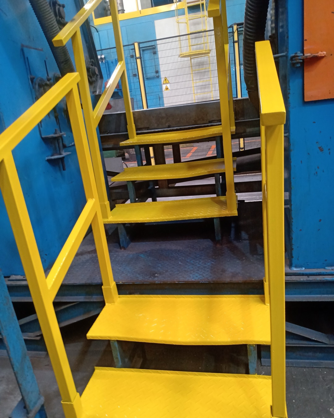 Escada industrial amarela com proteção lateral