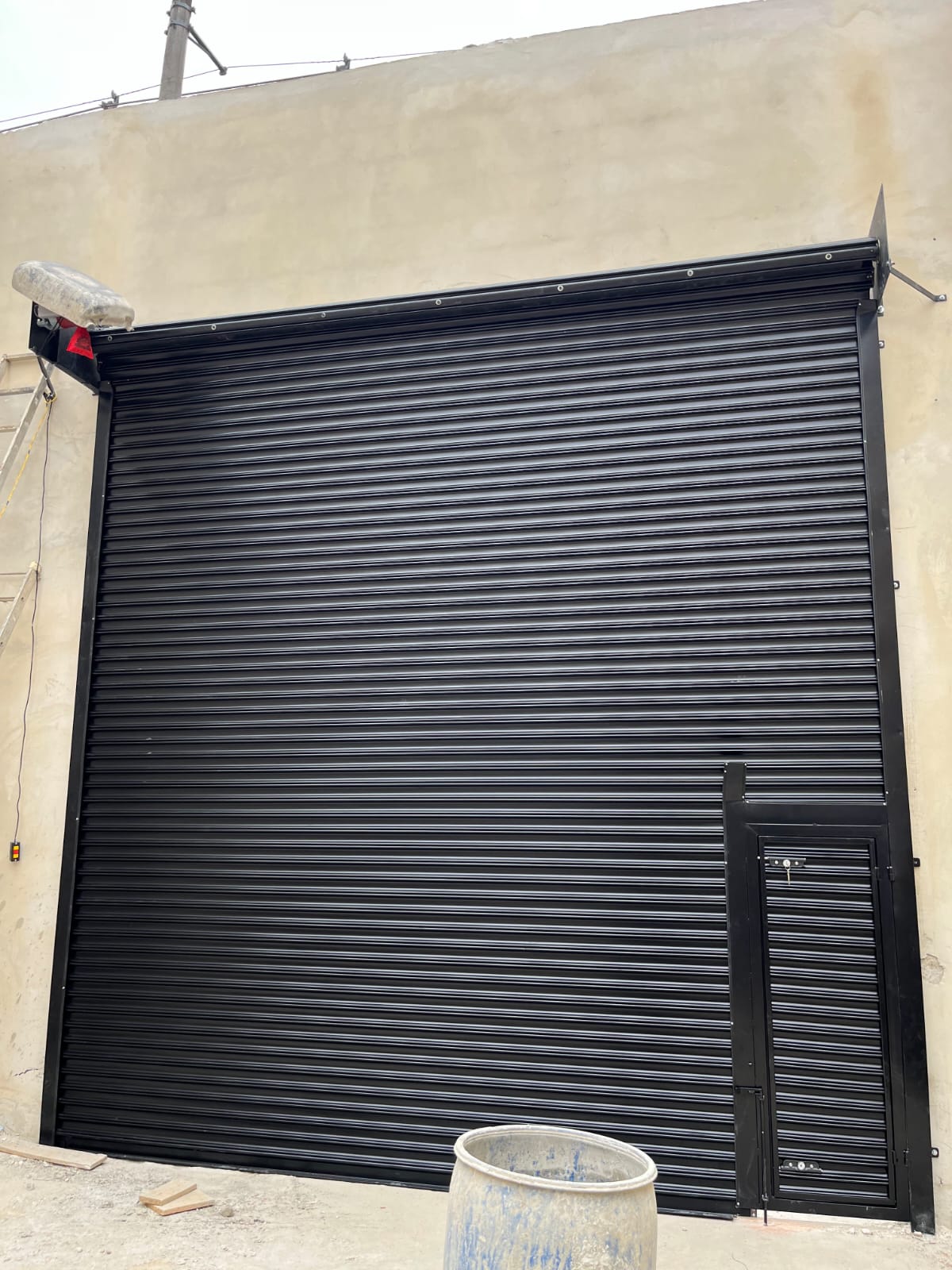 Porta de enrolar automática preta fechada com motor